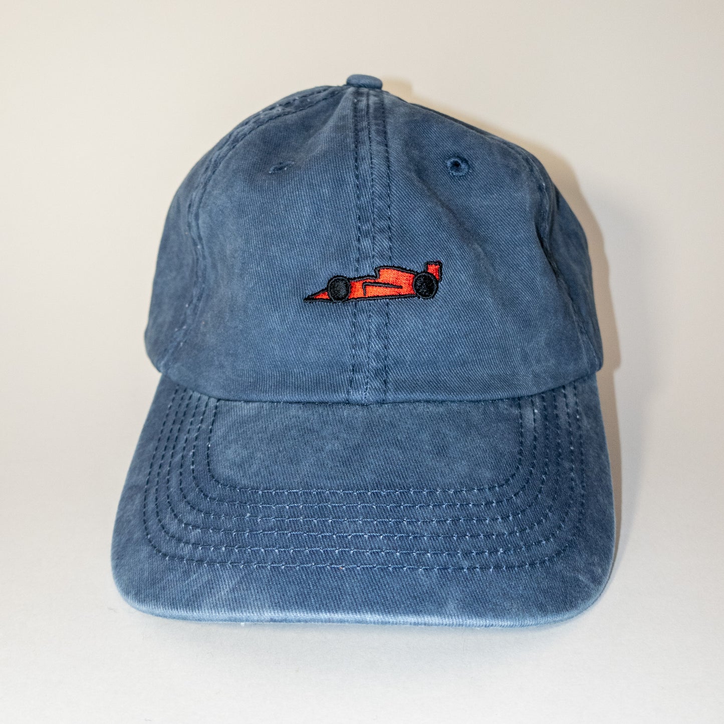 Red race car logo on washed blue hat